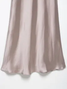 Close-up view of elegant silky satin dress fabric, showing smooth texture and drape hem.