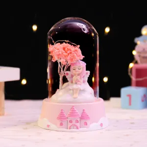 Close-up of cute fairy glass dome night light with glowing stars and pink castle base decor.