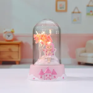 Close-up detail of the cute pink fairy glass dome night light with warm LED glowing tree.