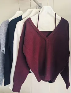 Women V-neck knit sweater detail view, cozy pullover top, soft material, multiple colors.