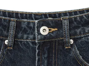 Primo piano dei dettagli della cintura di jeans blu scuro da donna con bottoni metallici.