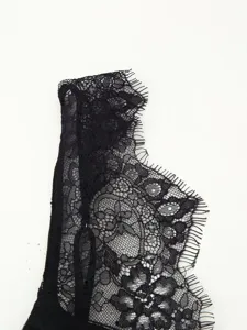 Close-up of elegant black lace trim detail, delicate floral pattern for stylish apparel.
