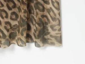 Leopard print mesh fabric detail close-up showing texture and pattern for stylish dress.