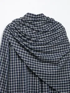 Detailed view of the French style blue and white plaid long sleeve shirt with unique draped design.