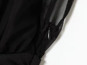 Primer plano detalle de vestido negro, con malla transparente y delicado diseño de cremallera.