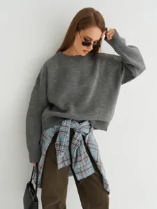 Dettaglio maglione lavorato a maglia grigio, comodo capo autunnale e invernale.