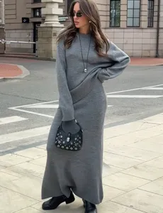Vue détaillée d'un ensemble de pull et jupe en tricot gris confortable porté en extérieur.