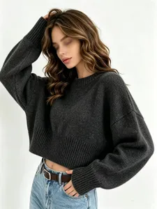 Detail shot of women's dark grey knit sweater, cozy long sleeve loose autumn wear.