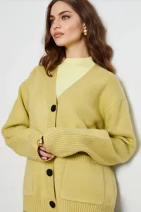 Vista detallada de cárdigan de punto para mujer en verde chartreuse con botones.