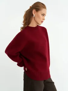 Primo piano sulla trama del morbido maglione in maglia bordeaux con dettagli a coste.