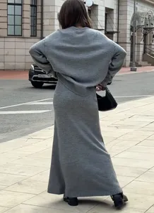 Vue détaillée de l'ensemble pull et jupe longue en tricot gris en style de rue en plein air.