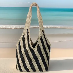 Vue détaillée du sac de plage en paille à rayures diagonales noires et blanches, tissage.