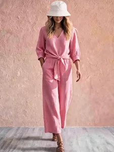 Pink tie-front v-neck jumpsuit detail shot, casual resort wear style with half sleeves.