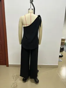 Details of black one-shoulder sleeveless top and wide-leg trousers set shown from behind.