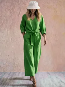 Detailed view of the green V-neck tie-waist jumpsuit with three-quarter sleeves for casual wear.