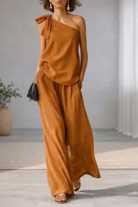 Detail view of the elegant one shoulder sleeveless top and wide leg pants in caramel.