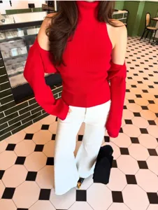 Women red halter turtleneck knit sweater set with detachable sleeve shawl and white pants.
