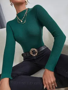 Close-up detail of dark green ribbed knit sweater featuring mock neckline and fitted style.