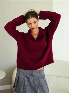Nahaufnahme des bordeauxroten Strick-Polypullovers zeigt die weiche Textur, Kragen und Bündchen.