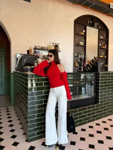 Red halter knit sweater two-piece set detail view in a stylish cafe interior setting.