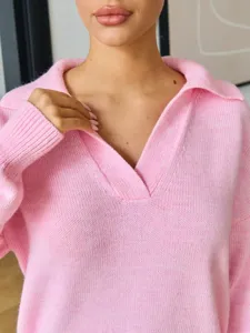 Detalle de jersey de punto rosa con textura suave, cuello polo clásico y ajuste cómodo.