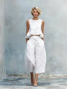 White linen blend two piece set featuring a sleeveless ruffle crop top and wide leg pants.
