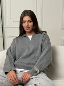 Suéter de punto gris holgado para mujer con un elegante cuello polo y manga larga.