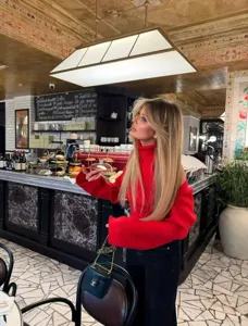 Λεπτομερής παρουσίαση ενός κομψού κόκκινου πουλόβερ μακριού μανικιού σε όμορφο καφέ.
