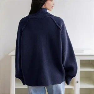 Detailed view of women's dark blue turtleneck knit sweater, loose fit and cozy autumn winter.