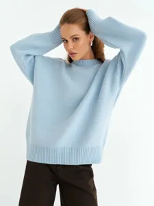 Dettaglio maglione in maglia azzurra, morbida di lana, maniche lunghe ampie e comode.