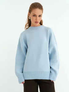 Dettaglio del maglione in maglia azzurra, tessuto morbido e confortevole, vestibilità comoda.