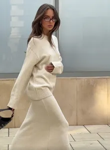 Détail d'ensemble pull en tricot beige et jupe longue, tenue d'automne décontractée.