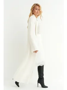 Lang wit gebreid vest detail shot, zachte textuur, elegante mode look voor de herfst.