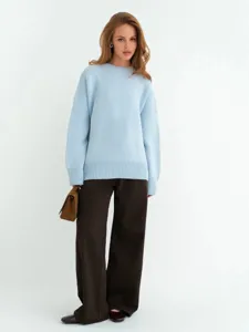 Primo piano dettagliato di un maglione lavorato a maglia azzurro largo da donna con scollo.