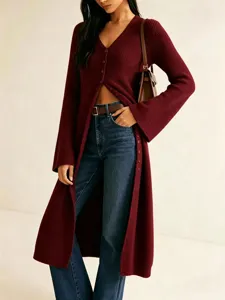 Detailansicht einer langen roten Strickjacke mit V-Ausschnitt und weichem Strickmaterial.