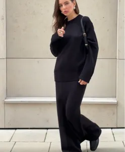 Vue détaillée du pull et de la jupe en tricot noir élégant, montrant le tissu doux et ample.