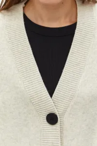 Vista de cerca de un cárdigan de punto beige para mujer con cuello en V y botón.