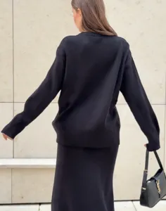 Vue détaillée d'un pull en tricot noir confortable et d'une jupe midi au style décontracté.