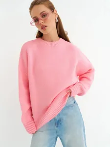 Dettaglio di un morbido maglione lavorato a maglia rosa, comodo e casual per ogni giorno.