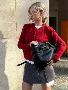 Detailansicht eines stilvollen roten Strickcardigans mit Rundhalsausschnitt für Damen.