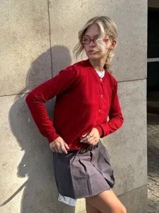 Detailansicht des roten Strickcardigans mit Knopfleiste und klassischem Rundhalsausschnitt.