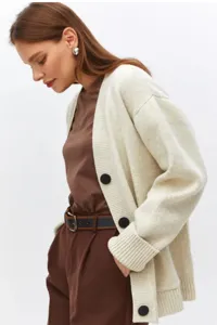 Detalle en primer plano de la elegante chaqueta de punto suave con textura y botones.