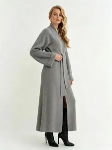 Detail van lang grijs gebreid vest met relaxte pasvorm, bijpassende ceintuur en fijne textuur.
