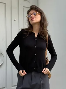 Detailansicht des schwarzen Strickcardigans mit klassischem Rundhalsausschnitt und Knöpfen.