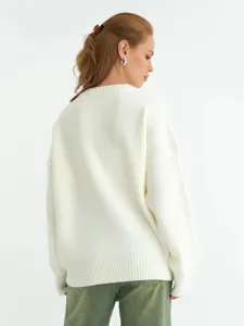 Dettaglio posteriore di un comodo maglione in maglia bianca con vestibilità ampia ed elegante.