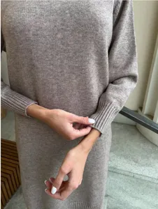 Primo piano del polsino dell'abito in maglia da donna, consistenza morbida e costine.