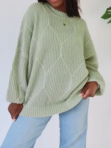 Nahaufnahme eines gemütlichen mintgrünen Zopfmuster-Pullovers mit weicher Textur.