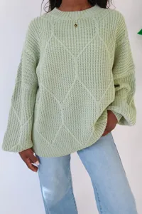 Nahaufnahme des hellgrünen Strickpullovers mit Rautenmuster und gemütlicher Passform.