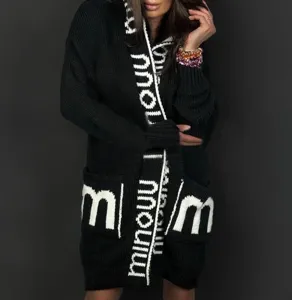 Schwarze Kapuzen-Strickjacke im Detail mit auffälligen weißen Buchstaben und geräumigen Taschen.