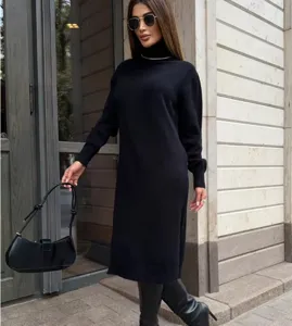 Dettaglio ravvicinato di un abito in maglia nero indossato con stivali in contesto urbano.